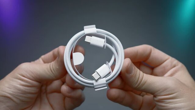 Close-up of type C wire for charging phone. Action. Type-C connector for charging phone on isolated ofn. New wire type C and included for phone