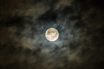 Naklejka na ściany i meble Full moon in the dark night sky with clouds. Halloween background,dark clouds, closeup.