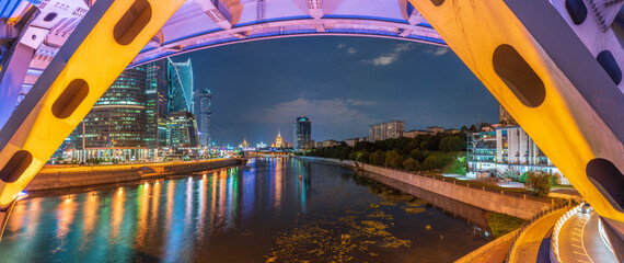 The scyscrapers of the Moscow City at night and the Dorogomilovsky bridge with illumination.