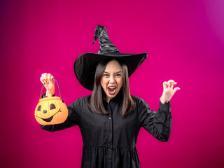 Portrait of an Asian Indonesian woman wearing a Halloween-themed costume with a witch hat, striking...