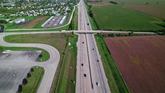 Red Semi Truck driver with white trailer driving on bridge overpass above Interstate I-90 Illinois Belviedere.