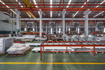 Metal sheets and steel sheet roll are placed on the floor in metal sheet factory. Large crane and...