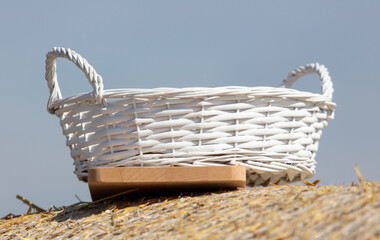 A white basket lies on a haystack. Close-up