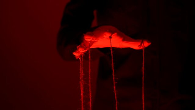 Manipulator hands in white gloves with ropes on fingers