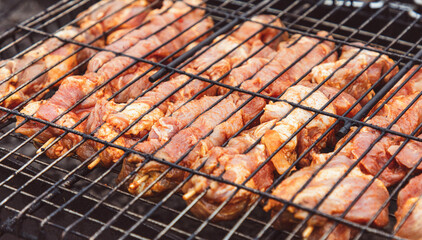 The meat is fried on the grill over the coals of the grill