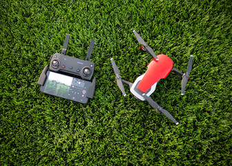 a drone with a remote control is lying on a green lawn, a drone with a remote control