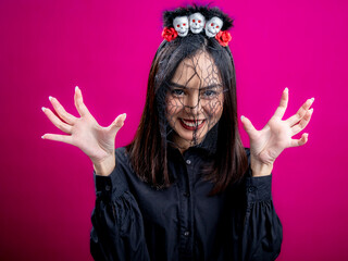 Portrait of an Asian Indonesian woman wearing a Halloween-themed costume, smiling, and looking...