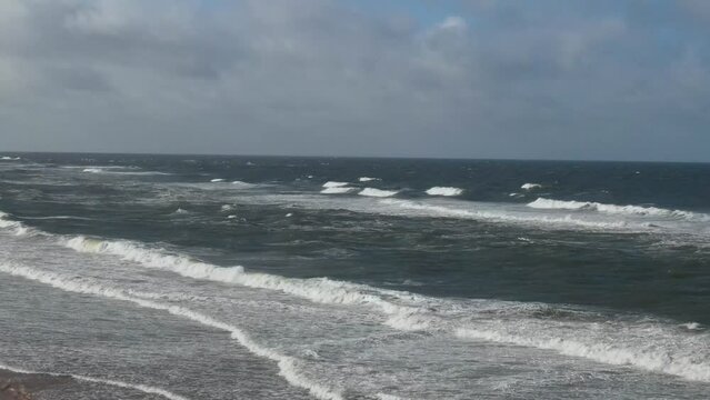 Kite Surfing at British Beach of England. High angle Drone's Camera Footage in Strong Winds and High Waves over Ocean