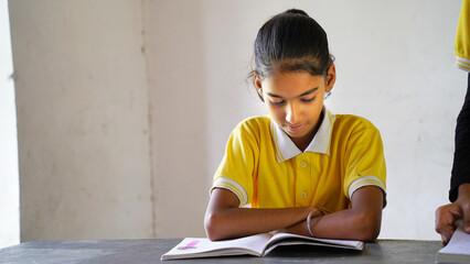 Indian school child sitting at desk in classroom with notebooks writing test Elementary school, Education concept. - obrazy, fototapety, plakaty