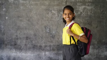 Fotobehang Portrait of happy indian teenager school girl with backpack holding books. Smiling young asian female kid looking at camera. © Govind