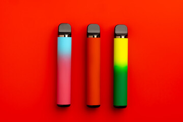Disposable electronic cigarettes on red background close up