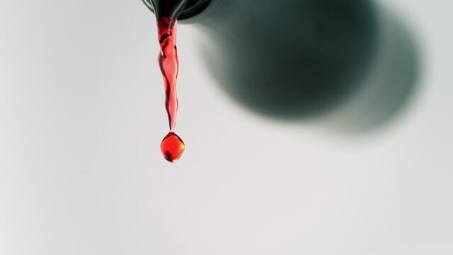 Super Slow Motion Shot of Camera Following Red Wine Stream from Bottle into Glass at 1000fps.