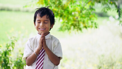 Portrait of Indian School Boy Praying in school ground - obrazy, fototapety, plakaty