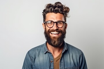 Portrait of a handsome hipster man in eyeglasses smiling and looking at camera isolated over gray background - obrazy, fototapety, plakaty