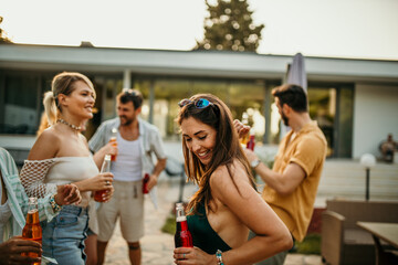 A cheerful group of friends enjoying a sun-kissed day in a vibrant backyard party, swaying to the rhythm by the shimmering pool, with refreshing drinks in hand