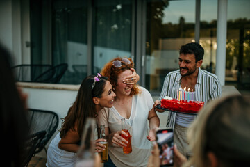 A cheerful group of friends gathers in a sun-drenched backyard, sharing laughter and joy at a lively birthday celebration