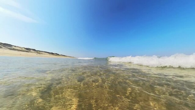 sanft brechende Wellen im klaren seichten Wasser, wundersch&ouml;ner einsamer menschenleerer Sandstrand, Horizont, Brandung, Wellen
