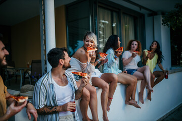 Friends chilling out, eating, and drinking during a sunset hangout in a yard