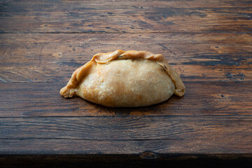 Closeup of a vegetable Cocarrois, on a brown wooden background.Typical empanadas from Mallorca