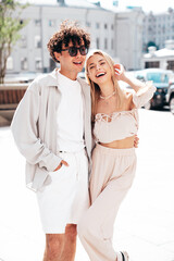 Portrait of young smiling beautiful woman and her handsome boyfriend in casual summer clothes. Happy cheerful family. Female having fun. Couple posing in the street background at sunny day