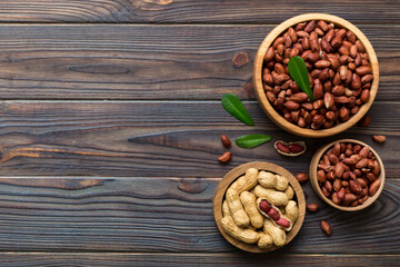 Fresh healthy peanuts in bowl on colored table background. Top view Healthy eating bertholletia concept. Super foods