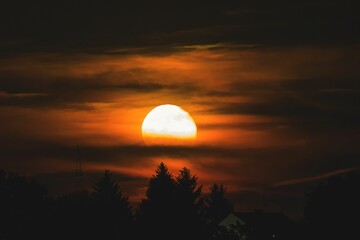 a bright sun is seen above the clouds in a black sky