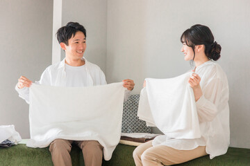 洗濯物を畳む・仲良く家事をする夫婦・カップル

