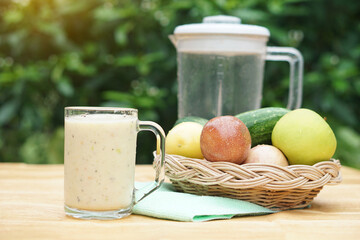 Glass of smoothie mixed fruits, basket of fresh fruits and blender. Concept, healthy beverage for...