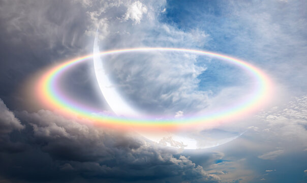 Rainbow surrounds the crescent moon with cloudy sky 