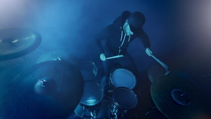 Professional Drummer Playing Drums in Studio with Neon Lighting Atmosphere.
