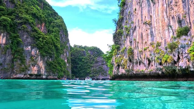 Phi Phi island off the coast of phuket thailand. Phi phi island is famous for turquoise clear blue waters teaming with Corel reef fish white soft sand and lush green trees.