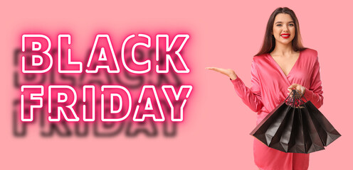 Beautiful young woman with shopping bags on pink background. Black Friday sale