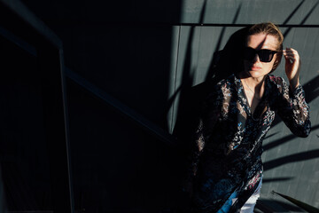 Beautiful fashionable woman in the shade of a plant indoors