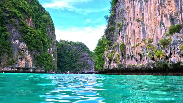 Phi Phi island off the coast of phuket thailand. Phi phi island is famous for turquoise clear blue waters teaming with Corel reef fish white soft sand and lush green trees.