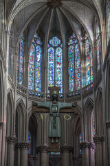 Interior of the cathedral Saint-Julien du Mans, cross of Jesus above the altar in front of the stained glass window - obrazy, fototapety, plakaty