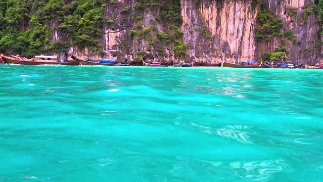 Phi Phi island off the coast of phuket thailand. Phi phi island is famous for turquoise clear blue waters teaming with Corel reef fish white soft sand and lush green trees.