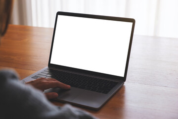 Fototapeta premium Mockup image of a woman using and working on laptop computer with blank white desktop screen