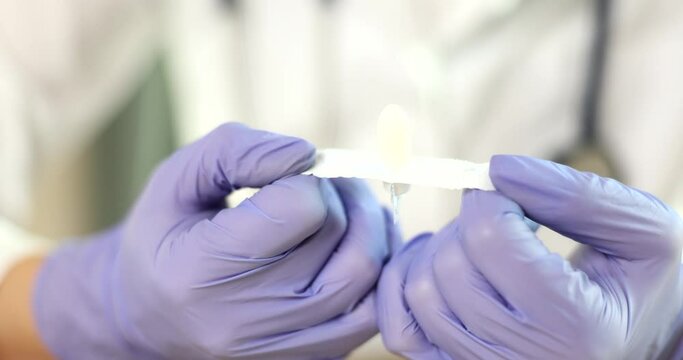 Doctor holding rectal suppositories in gloved hands closeup 4k movie slow motion. Hemorrhoids and anal fissure treatment concept