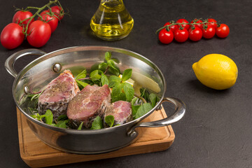 Fresh river fish and mint in pan. Cherry tomatoes, oil and lemon