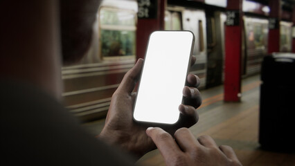 African-American Black male using his phone on New York subway station platform