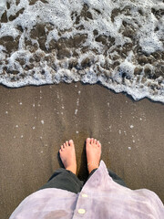 barefoot and waves on the beach, grounding concept.