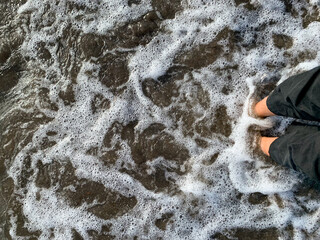 waves water flowing between feet on the beach, grounding concept.