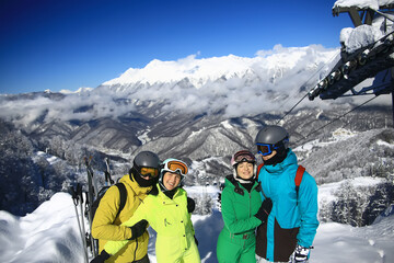 Fototapeta na wymiar group of four friends at a ski resort posing on a slope in winter