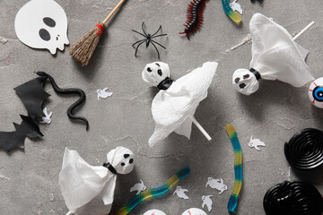 Tasty lollipops and Halloween decor on grey background