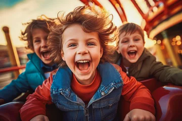 Poster Im Rahmen Mother and two children riding a roller coaster together having fun. Happy family on a fun roller coaster ride in an amusement park. Laughing. © VisualProduction