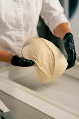 Raamstickers close-up of female hands in gloves putting dough into a bread shape on baking sheet for baking fresh pastries © Guys Who Shoot