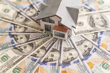 House standing on a pile of dollar bills. Investment, real estate and property concept - obrazy, fototapety, plakaty