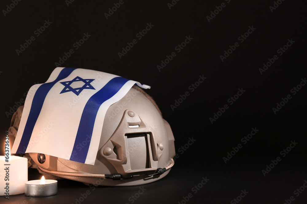 Wall mural Military helmet with flag of Israel and burning candles on dark background