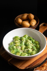 Food concept Spot focus Homemade creamy pesto gnocchi on black background with copy space