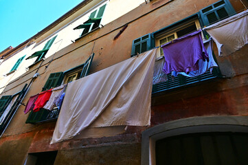 clothes hanging out to dry on an ancient mediterranean building seen from below